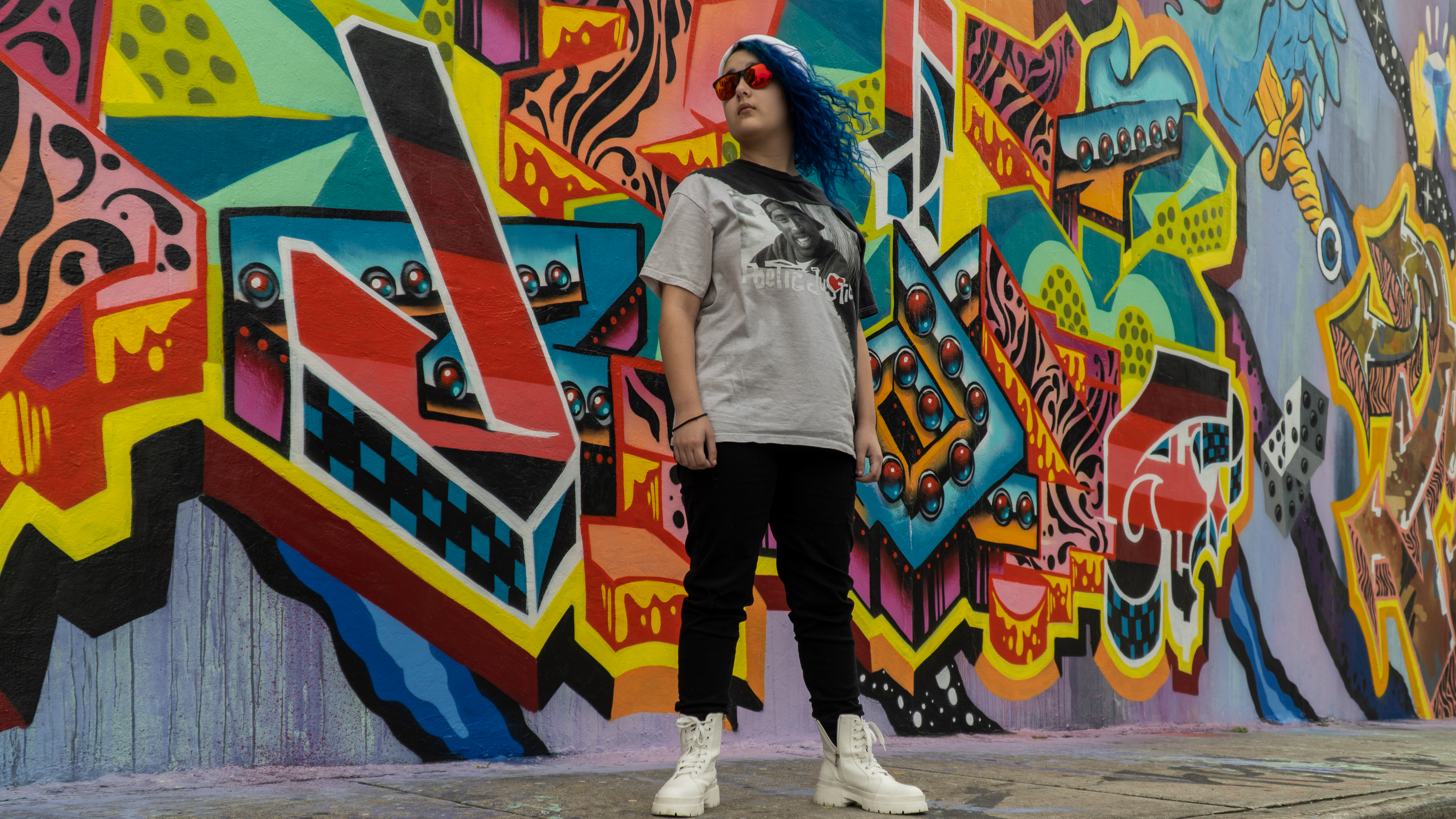 Fabu standing confidently in front of a colorful mural