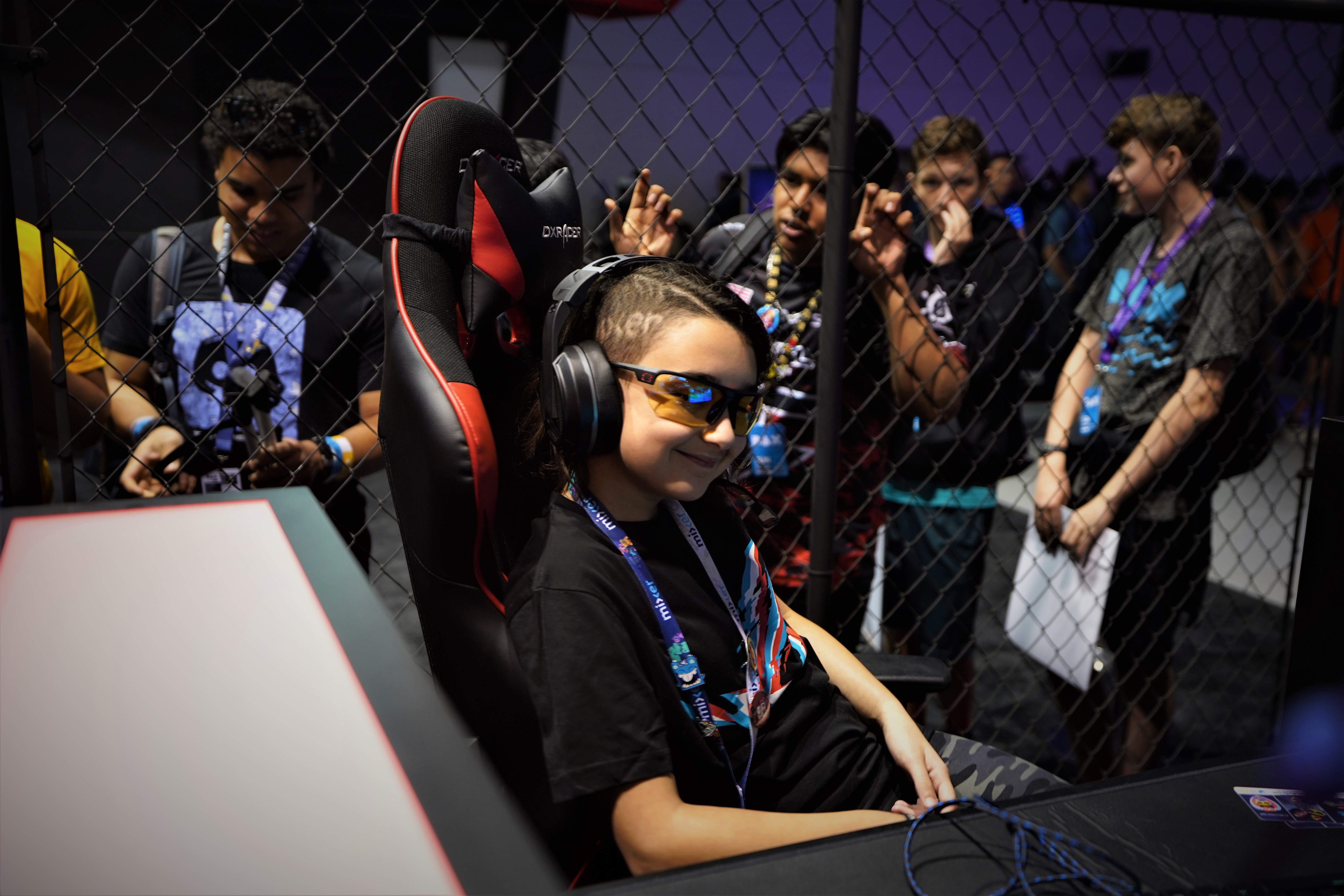 Fabu wearing headphones at a gaming station during an event