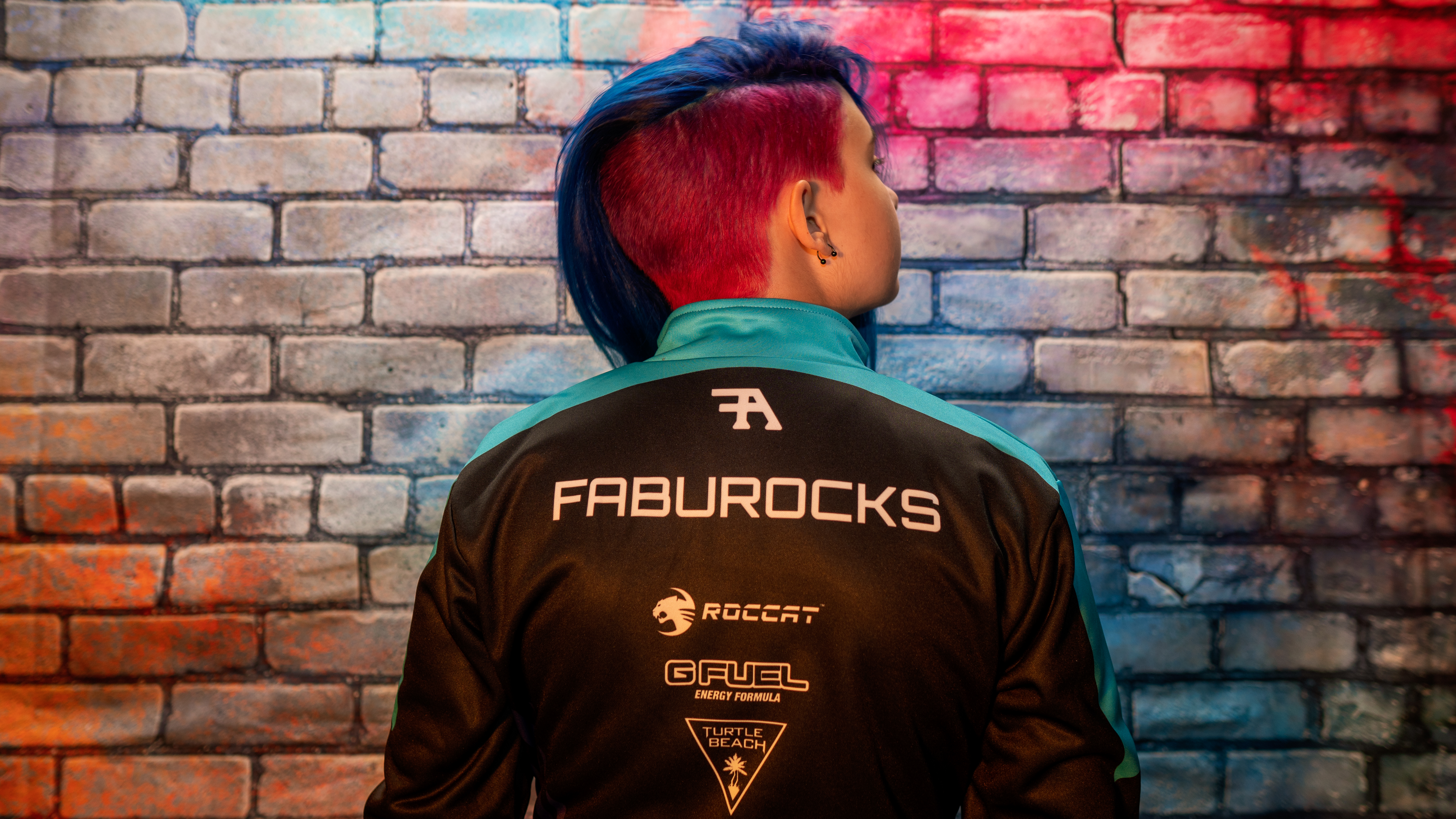 Fabu wearing the FabuRocks partner jersey against the brand portrait wall