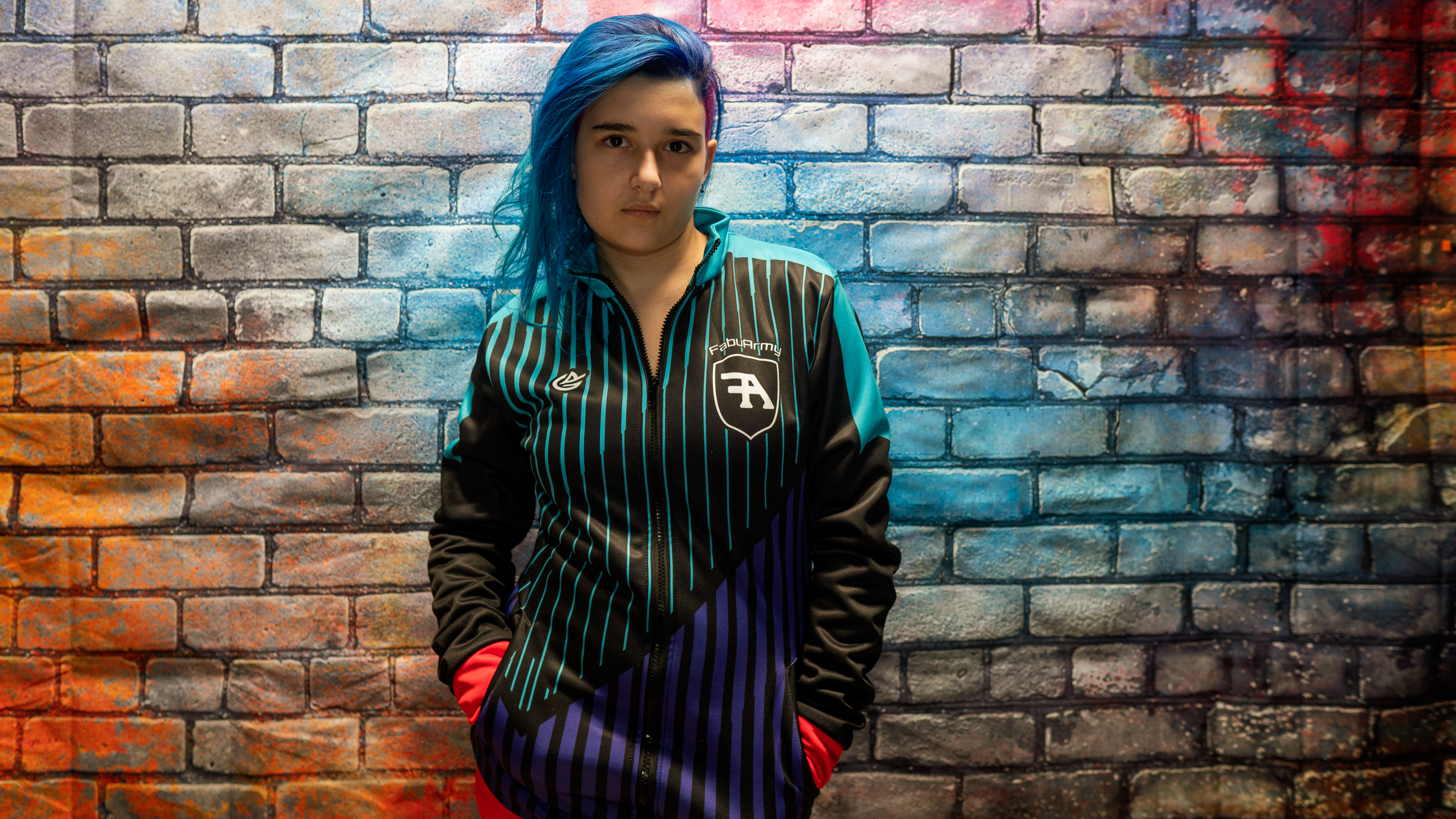 Fabu wearing a FabuArmy jacket in front of the brand portrait wall